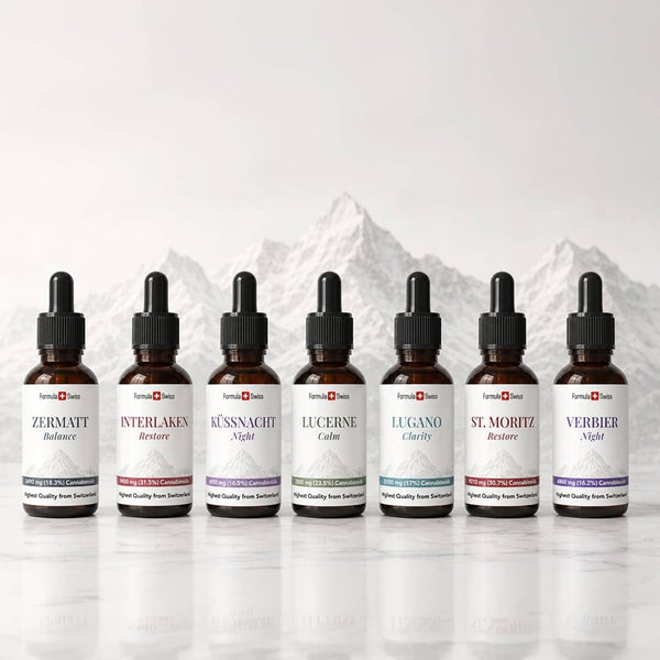 Raccolta di olio di CBD Formula Swiss con sette bottiglie contaconere di ambra esposte davanti a uno sfondo di montagna svizzero.